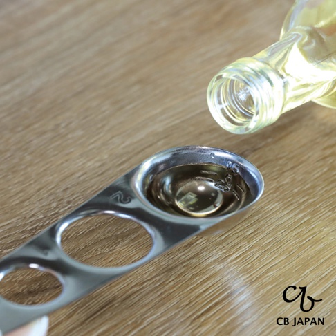 CB JAPAN 標誌旁，一瓶清澈液體正在傾倒進一個金屬量匙中，量匙上有 1.5 和 2 的刻度。