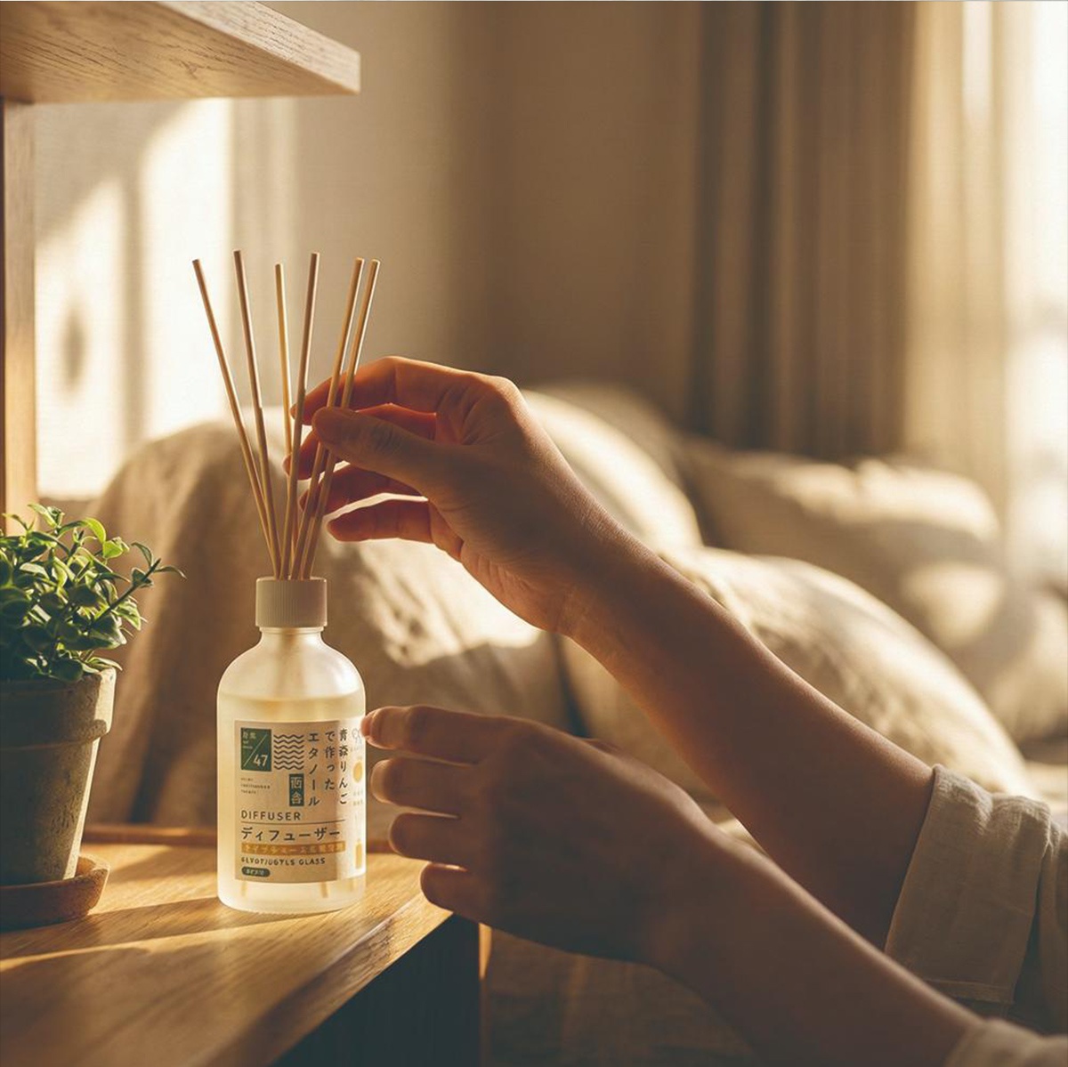 一雙手正在調整裝有擴香竹的玻璃瓶。