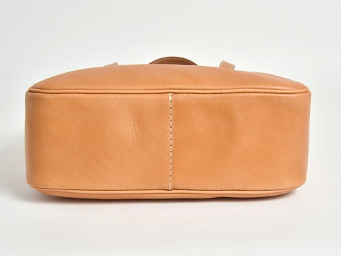 淺棕色皮革托特包，側面有精緻縫線裝飾，包身線條圓潤，採用簡約設計。