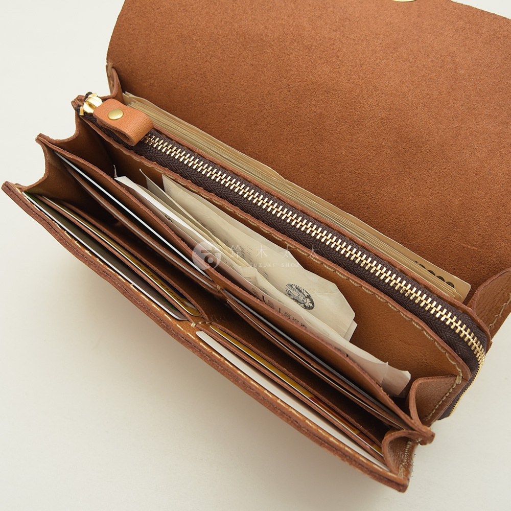 職人手作皮革長夾，展示其手風琴式多卡層結構，內部可見多張卡片與紙鈔，材質為棕色皮革，搭配金色拉鍊。
