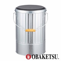 OBAKETSU 品牌的手工製金屬儲物桶，頂部帶有黑色軟墊，可用作凳子，側面有木製提手。