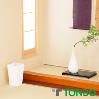 白色方形半開垃圾桶，材質為塑膠，容量5.5L，座落於日式榻榻米房間角落，旁邊有盆栽和掛飾。