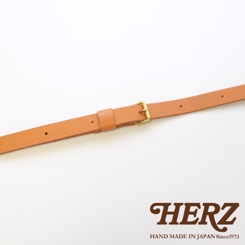 一條淺棕色皮革製的肩背帶，帶有金屬扣環和可調節的帶扣，背景為白色。