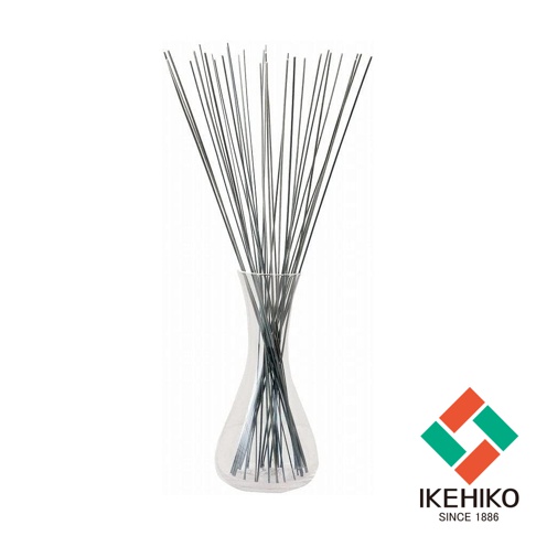玻璃花瓶中插著一把束狀的深灰色細長藺草，藺草末端朝上散開。