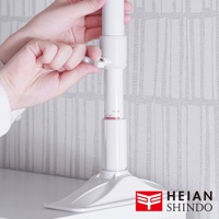 白色伸縮防傾桿，頂部有鎖定裝置，底部為寬大底座，用於固定。