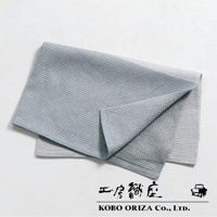 淺灰色棉麻混紡拭巾，具有標誌性的鬆餅紋理，一角向內摺疊，露出內裡的淺灰色。