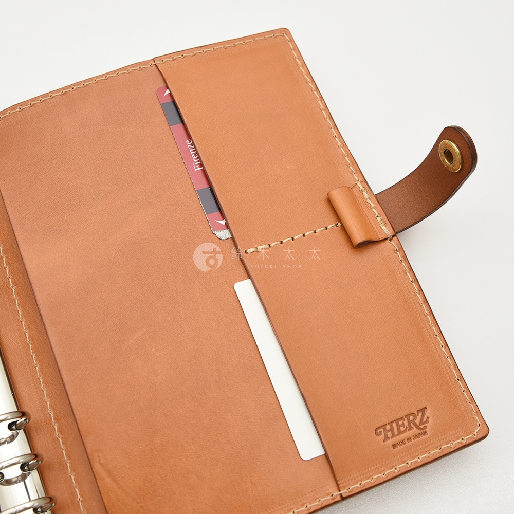 職人手作皮革A5手帳/記事本書套，淺棕色皮革，內有卡槽、筆插，附有金屬按扣，品牌HERZ字樣壓印於右側內頁。