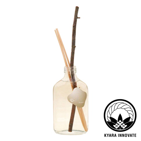 KYARA INNOVATE 品牌標誌旁，一個裝有澄清液體的玻璃瓶中，插入了兩支細長的擴香竹和一支較粗的樹枝，瓶身貼有一枚貝殼造型的標籤，上面寫著「Focus」字樣。