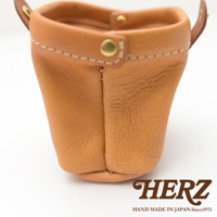 職人手作皮革口金化妝包，咖啡色皮革，帶有縫線和金色銅扣，底部圓潤，側面有皮革提把。