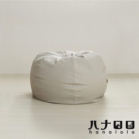 淺灰色皮革材質的圓形懶骨頭沙發，置於淺色木質地板上，背景為米白色牆面。