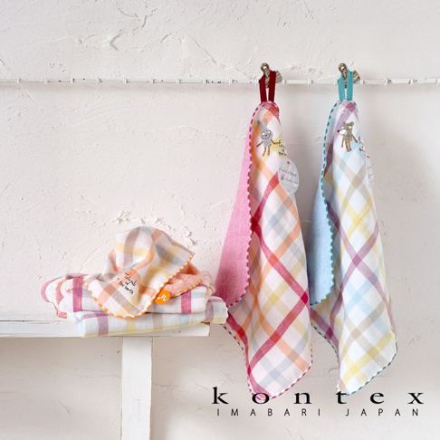 kontex IMABARI JAPAN 品牌下的兩條格子毛巾，一條粉紅色，一條淺藍色，懸掛在牆上，下方是疊放的幾條同款毛巾