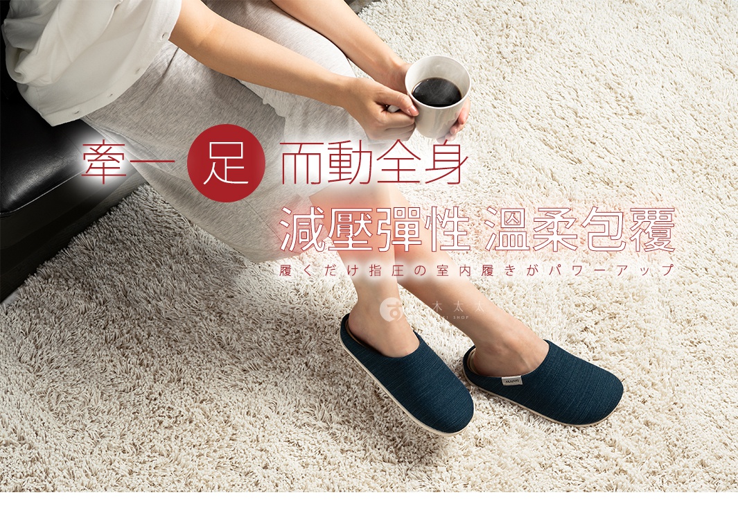 一雙深藍色、織紋材質的減壓包覆室內拖鞋，鞋面略有彈性，鞋後跟有品牌標誌。