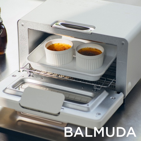 白色蒸氣烤麵包機，內部有兩個烤布蕾，放在白色烤盤上，烤盤置於烤網上。