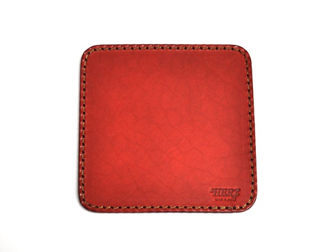 紅色皮革印章墊板，表面光滑，邊緣以深色線縫合，右下角壓印有「HERZ」品牌標誌。