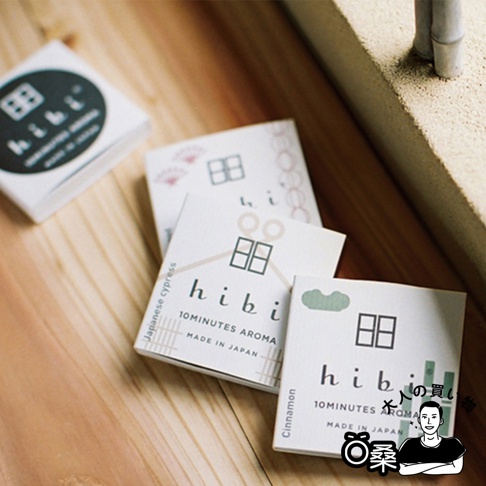和風限定款香氛火柴禮盒，包含三款不同香味的包裝，以簡約的白色紙盒呈現，上面印有「hibi」品牌標誌、日式房屋圖案及「Japanese cypress」、「Cinnamon」等香味名稱。