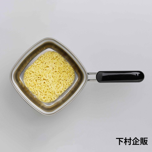 方形不鏽鋼單手麵鍋，鍋內裝有乾燥的黃色泡麵，鍋柄為黑色。