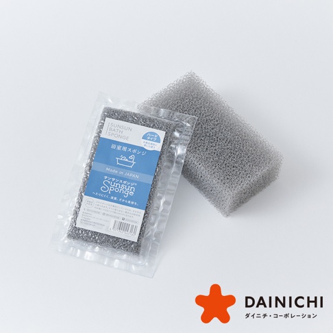 一個灰色的、網狀紋理的浴室清潔海綿，一塊裝在透明包裝袋中，另一塊裸露展示其材質。包裝袋上有日文和英文產品資訊，標示為「SUNSUN BATH SPONGE」，並有浴缸圖示。