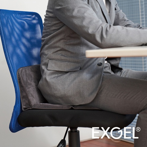 灰色布料製成的行動折疊腰靠坐墊，置於藍色網格椅背的椅子上，一位身穿灰色西裝的男子正坐在上面。