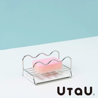 不鏽鋼製的萬用瀝水支架，上面放置著粉紅色海綿，支架設計簡約，邊緣呈波浪狀，適合置於廚房或浴室檯面。