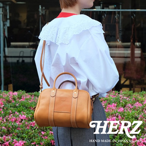 HERZ 職人手作皮革兩用迷你波士頓包，以柔軟親膚的Stare牛皮革製作，可手提或肩背，附有可拆式背帶，包身圓潤，搭配厚實提把，展現簡約俐落的設計風格。