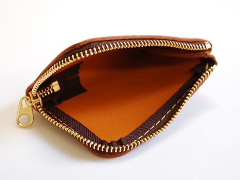 一個棕色皮革L型拉鍊卡片收納夾，展示其光滑的內裡和金色的YKK拉鍊，邊緣有縫線。
