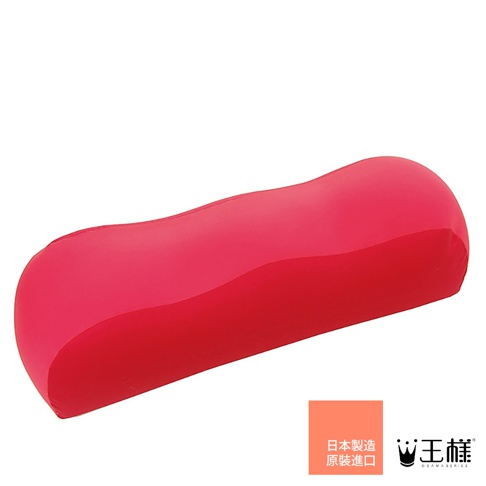 一個鮮紅色的膝下枕，形狀呈彎曲狀，表面光滑，具有人體工學設計，旨在支撐腿部。