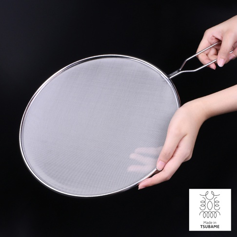 銀色金屬透視防噴濾網，網狀細密，邊緣光滑，配有金屬手柄，由雙手持握，背景為黑色。