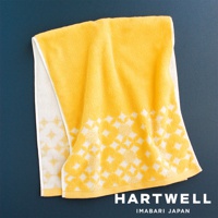 一條黃色毛巾，採用柔軟的棉質材質，飾有白色傳統和風幾何圖案，部分區域有白色邊緣。