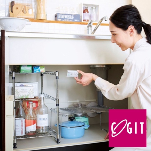 婦人將COGIT長效除臭防霉貼片放入廚房水槽下櫃的置物架上