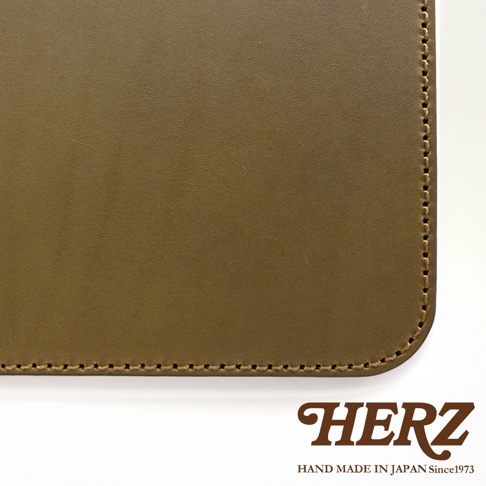 HERZ 品牌標誌，下方為HAND MADE IN JAPAN Since1973，背景為咖啡色皮革特寫