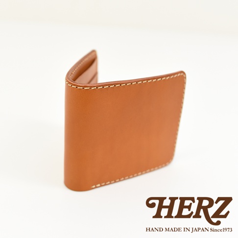 職人手作皮革二折橫式卡片紙鈔小短夾，呈現溫潤的淺棕色皮革，車縫線清晰。