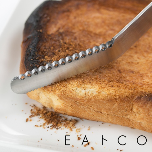 日製奶油刀，不鏽鋼材質，刀刃處有精緻的波浪鋸齒設計，刀身銀色，用於塗抹或切割吐司。