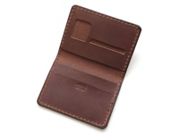 職人手作皮革雙折證件收納夾，深棕色皮革，內有證件夾層與卡片槽，邊緣縫線細緻。