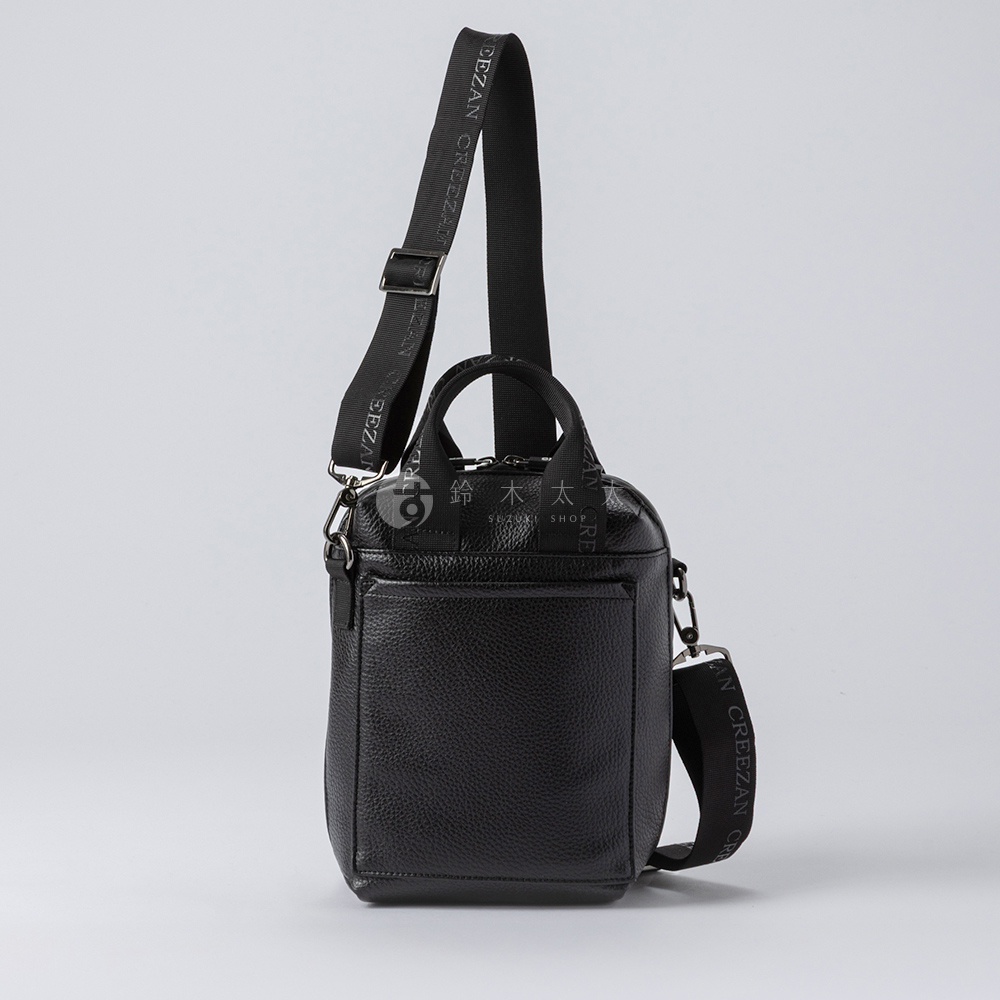 黑色皮革方形側背包，有兩個提把和一條可調式斜背帶，帶有品牌標誌。