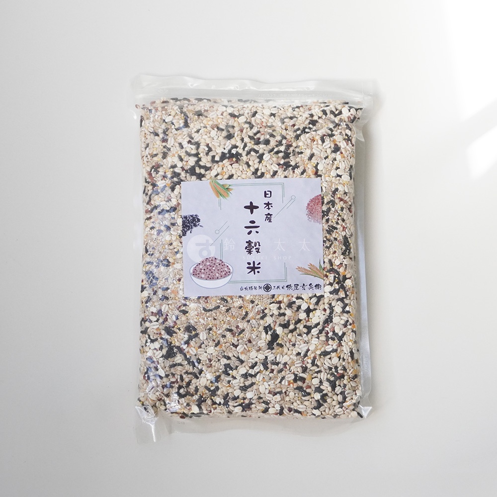 日本國產十六穀米 1kg 透明包裝袋，內含多種不同顏色和大小的穀物，包括白色、黑色、棕色、紅色等，混合均勻，中央貼有印有「日本國產 十六穀米」及碗裝穀物圖案的長方形標籤。