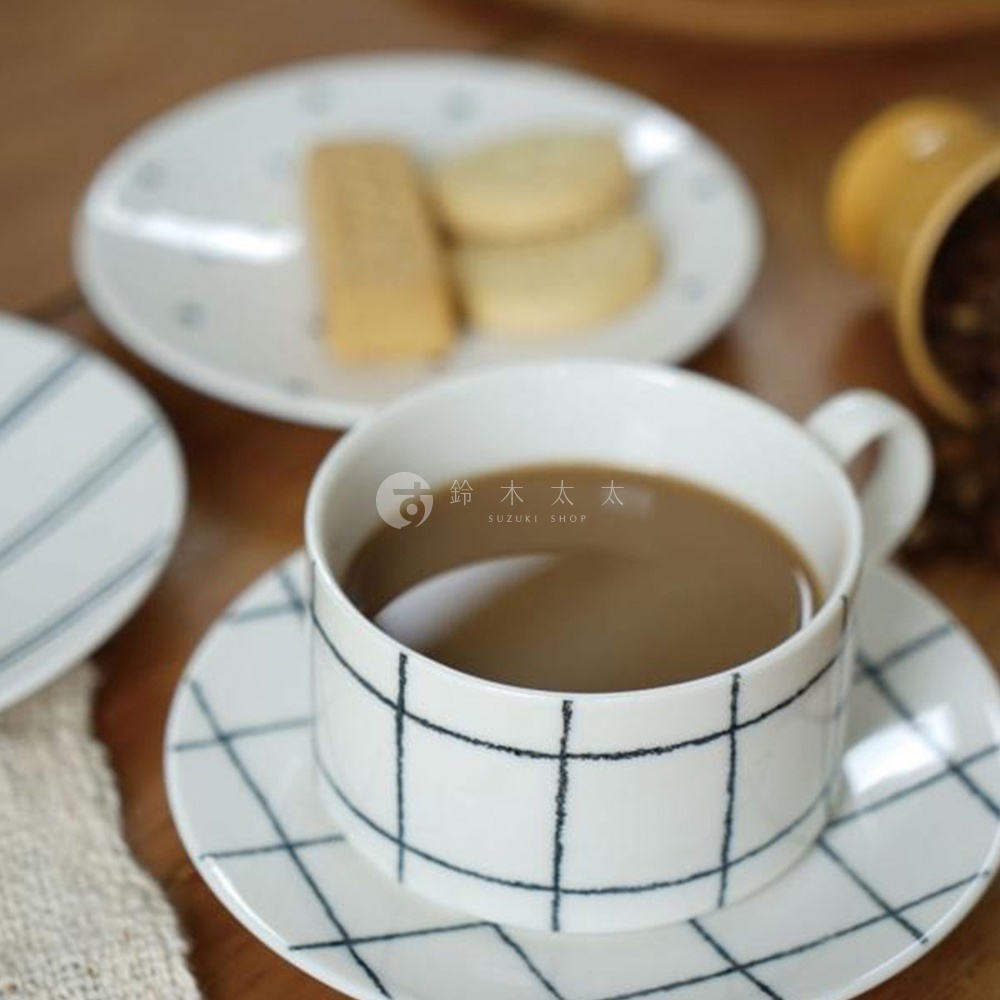 gohara mamiko 美濃燒手繪點心盤，白色陶瓷盤身，點綴藍色細線條圖案，搭配一杯咖啡，旁邊另有兩塊餅乾，展現日式簡約風格。
