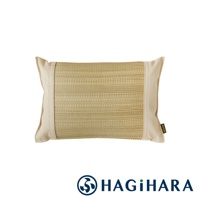 藺草編織的長方形枕頭，兩側為米白色布料包邊，枕頭中央的藺草呈現自然淺褐色，整體風格簡約。