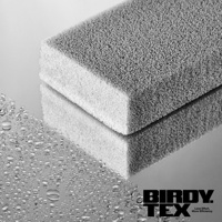 光滑鏡面上放置著一個專業玻璃杯耐用海綿刷，海綿刷為灰色，帶有細密的孔洞，一側為白色較細緻的海綿。