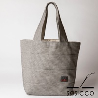 三河木綿刺子織大容量托特包，以黑白細格紋圖案為主，搭配水平縫線，設有寬版提把。包身角落有紅色品牌標籤。