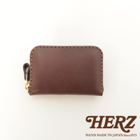 深棕色職人手作皮革拉鍊收納錢包，帶有黃銅拉鍊頭和皮革拉環，車縫線清晰可見。