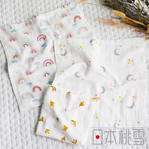 三條日本桃雪品牌的紗布方巾，分別印有彩虹、月亮與星星、以及橘子圖案，其中兩條較大，一條較小，下方還有一行日文「日本桃雪」。