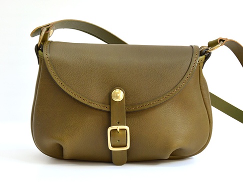 橄欖綠皮革馬鞍包，帶有金色金屬扣環和可調節肩帶，適合休閒旅行。