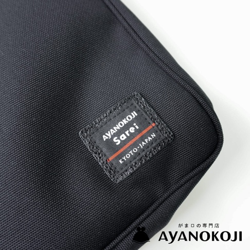 黑色機能布斜背包，上面有 AYANOKOJI Sarei KYOTO.JAPAN 品牌標籤