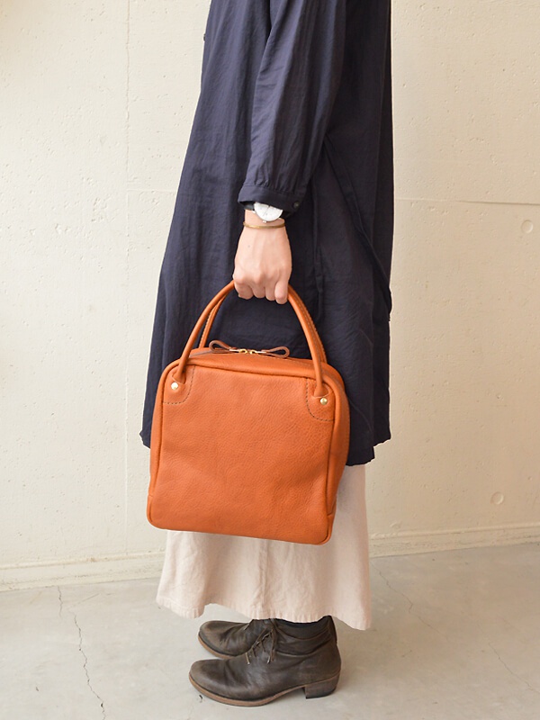 職人手作皮革Organ方形托特包，M尺寸，呈現溫暖的橘色調，採用柔軟皮革材質，質感細膩，包身線條流暢，設計簡約大方。