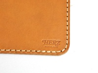 職人手作皮革印章墊板，淺棕色皮革，手工縫線，壓印有「HERZ MADE IN JAPAN」字樣。