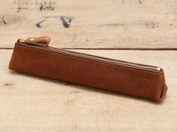 職人手作皮革Organ三角收納筆袋，採用咖啡棕色皮革製成，搭配金色拉鍊和皮革拉頭，設計簡約，適合收納文具。