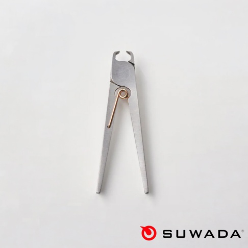 銀白色的日本 SUWADA 諏訪田製作所 Petite 波堤指甲剪平放在淺色背景上，金屬剪刀主體中央配有一個銅色的金屬彈簧，右下方印有紅色的品牌標誌與 SUWADA 字樣。