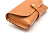 職人手作皮革眼鏡收納盒，淺棕色真皮材質，帶有縫線與黃銅色按扣。