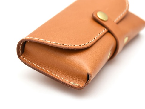 職人手作皮革眼鏡收納盒，淺棕色真皮材質，帶有縫線與黃銅色按扣。