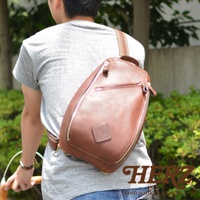 職人手作皮革多功能收納斜背包，採用棕色皮革材質，設計簡約，配有拉鍊開合和可調節肩帶，適合日常攜帶。